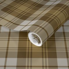 a brown and white plaid wallpaper with a rolled up roll on the floor next to it