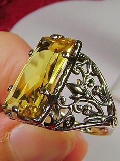 Yellow Citrine Ring Baguette Design#32 Introducing the Baguette D32, a stunning piece of wearable art that pays homage to the opulent Victorian era. Crafted with meticulous attention to detail, this exquisite filigree Antique reproduction in sterling silver is sure to captivate anyone with a love for vintage-inspired jewelry. At its center, lies a flawless 7ct yellow gemstone, radiating a dazzling hue that catches the light with every movement. The baguette rectangle-cut gemstone measures a rema Luxury Yellow Baguette Cut Jewelry, Yellow Rectangular Gemstone Rings, Elegant Oval Crafted Jewelry, Elegant Yellow Rectangular Rings, Luxury Yellow Rectangular Rings, Classic Yellow Rectangular Rings, Luxury Yellow Rectangular Ring, Yellow Rectangular Anniversary Ring, Formal Yellow Rectangular Rings