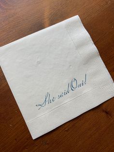 a napkin with the word me said oui on it sitting on a wooden table