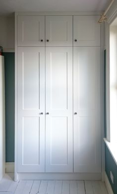 an empty room with white cupboards and blue walls