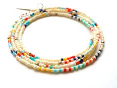 Ivory glass seed beads with stripes and 14k gold filled accents. The pieces can be worn as a wrap bracelet, necklace, or anklet. Measures 27". Adjustable White Waist Beads With Tiny Beads, Adjustable White Bohemian Waist Beads, White Heishi Beads Hand-strung Necklaces, White Heishi Beads Necklaces Hand-strung, White Hand-strung Heishi Bead Necklaces, Hand-strung White Heishi Bead Necklaces, Hand-strung Heishi Bead Jewelry For Summer, White Multi-strand Beaded Bracelets For Beach, White Heishi Beads Single Strand Necklace