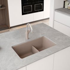 a kitchen sink sitting under a window next to a counter top