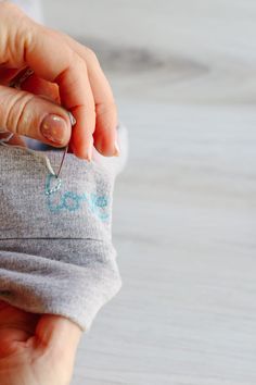 a woman holding onto a small baby's diaper with the word love written on it