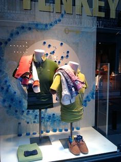 two mannequins in front of a window display with shirts and shoes on it