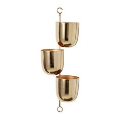 three metal cups hanging from hooks on a white wall