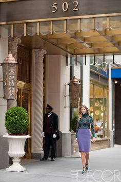 a woman is walking down the sidewalk in front of a building with a sign that reads 502