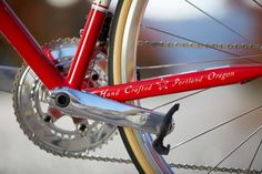 a close up of a red bicycle with the words hand crafted portland oregon on it