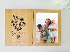 an open wooden photo album with flowers and the words grandma written in black on it