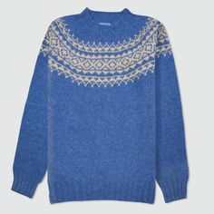 "Scottish Fair Isle style men's mid blue lambswool jumper made from a soft natural yarn, with a traditional neck detail. Here's a contemporary and elegant twist on a classic Christmas style jumper. Allaster Fair Isle is a new take on an old favourite. The soft mid blue lambswool wool is brought alive by natural white yoke design. Our choice of colours gives a modern edge to a classic design. Finished with a crew neck with lightly ribbed neck, cuffs and hem. Our Allaster sweaters are beautifully Nordic Blue Crew Neck Sweater, Blue Nordic Crew Neck Sweater, Blue Wool Sweater With Fair Isle Pattern, Nordic Knitted Blue Sweater, Blue Nordic Sweater With Fair Isle Pattern, Blue Fair Isle Pattern Winter Sweater, Cozy Blue Sweater With Fair Isle Pattern, Alpaca Sweater With Fair Isle Pattern And Crew Neck, Scandinavian Hand Knitted Crew Neck Sweater