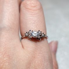 a woman's hand with a diamond ring on top of her finger and an engagement band