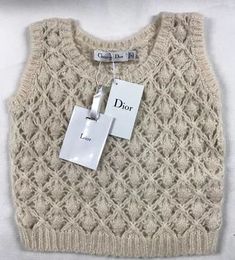 a white sweater with a tag on it and some tags attached to the back of it