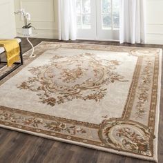 a large area rug with an ornate design on the floor in front of a window