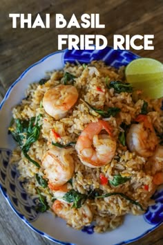 thai fried rice with shrimp and spinach in a blue and white bowl on a wooden table