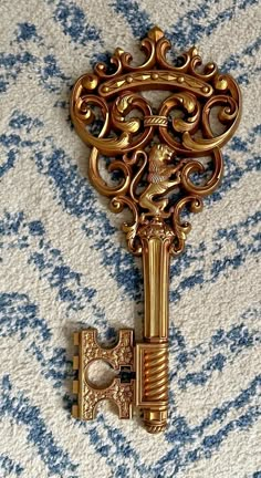 an ornate gold key on a blue and white background