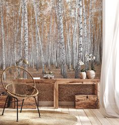 a chair and table in front of a wall with a forest mural on it's side