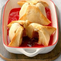 some food is in a red dish on a wooden tray