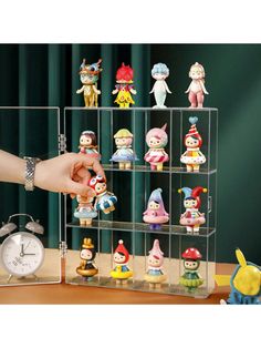 a person holding a small toy in front of a shelf with many little figurines on it