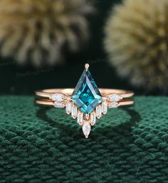 an engagement ring with a blue topazte and white diamonds on the side, sitting on a green surface