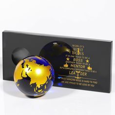 two black and gold balls are next to a plaque that says world's best boss