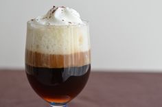 a glass filled with liquid sitting on top of a table