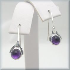 "Gorgeous amethyst cabochon earrings - a rich, deep purple that looks absolutely luscious. The setting is slightly oxidized sterling to make the stone really stand out. Beautiful for anyone who loves purple or as a gift for that person with a February birthday. The earrings are about 7/8\" long (2.2 cm) from top of earwire. Sterling silver. The amethyst cabochons are 5 mm in size. Jewelry is packaged in a cotton lined box for gift-giving. See more Bonny Jewelry at http://bonnyjewelry.etsy.com" February Gift, Purple Amethyst Earrings, Cabochon Earrings, February Birthday, Birthstone Earrings, February Birthstone, Birthstone Earring, Amethyst Earrings, February Birth Stone