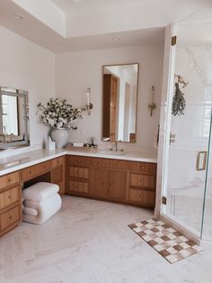 a large bathroom with marble floors and wooden cabinets