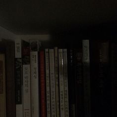 a shelf filled with lots of books in a dark room