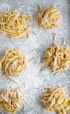 six uncooked pastas on a baking sheet