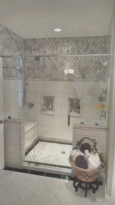 a bathroom with a walk in shower next to a sink and bathtub, along with a basket on the floor