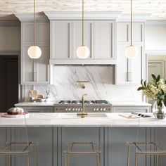 a kitchen with marble counter tops and gold bar stools in front of an island