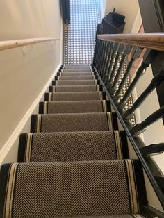 the stairs are lined with black and white carpet