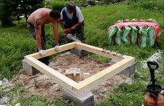 two men are working in the yard with tools and cement blocks to build a fire pit