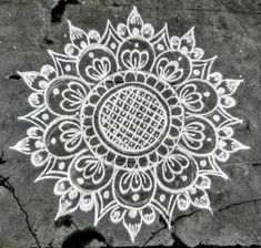 an intricate design is drawn on the ground with white chalk and watercolor pencils