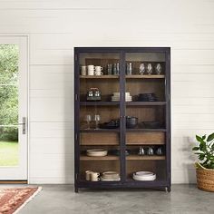 an open bookcase with glass doors on the front and side, in a room with white walls