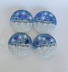 four glass coasters with snowflakes and santa's sleigh on them