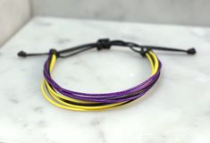 "Simple, yet stylish this waxed cord bracelet is 100% waterproof you can shower and swim with it on without taken it off. It is adjustable and fits size 5-9\" wrists. I have had my bracelets on since Mother's Day weekend and have never taken them off. They still look brand new! Style Incldues: *Black, Purple and Yellow(Other colors available) * Adjustable 5-9\" * Handmade in Minnesota by Flying Bird Jewelry * Cheap Shipping Color Options: * If you'd like to customize your bracelet colors select Pride Colours, Bracelet Colors, Wax Cord Bracelet, Mothers Day Weekend, Purple And Yellow, Bird Jewelry, Cord Bracelet, Cheap Jewelry, Cord Bracelets