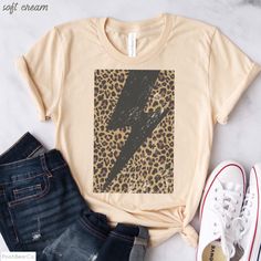 Trendy, distressed cheetah bolt design with a bohemian vibe from PoohBearCo. Send the message that you're strong, and you can do this! Game on! Super-soft graphic tee with a vintage look and feel. If you like a more fitted style, please size down. Refer to size chart in photos and compare measurements to those of a shirt you already own that you love. Solid colors: 100% Preshrunk Cotton Heather Colors: 52% Cotton / 48% Poly * Pre-shrunk * Shoulder-to-shoulder taping * Side-seamed cheetah bolt gr Boho Cheetah, Monogram Shirt, Lighting Bolt, Soft Graphic, Leopard Shirt, Monogram Shirts, Fitted Style, Game On, Shirt Ideas