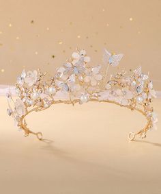 a gold tiara with flowers and butterflies on the headpiece is seen in this image