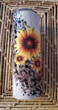 a white and yellow vase sitting on top of a wicker table next to a bamboo mat