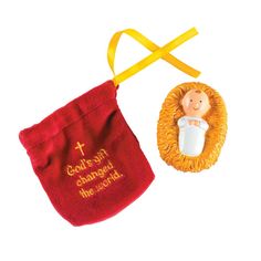 an ornament with a red bag next to it and a yellow ribbon around it