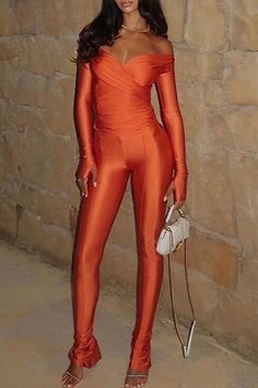 a woman in an orange jumpsuit posing for the camera