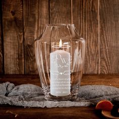 a glass vase with a candle inside on a table