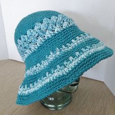 Hand crochet sun hat with a flexible  brim is crocheted  in a turquoise  teal blue cotton yarn.  Rows of teal cotton yarn alternate with a teal and white yarn striping for the hat band and on the brim.  The crochet is a sturdy close  stitch giving the hat good body and shading coverage when worn at the  beach or gardening.  With the flexible brim you have a versatility of styling the hat as you please and the hat folds neatly for packing.  The size of the hat will fit most adult women or teens. Crochet Sun, Crochet Sun Hat, Summer Sun Hat, Le Crochet, Bleu Turquoise, Beach Hat, Crochet Hat, Hat Band, Brim Hat