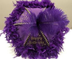 a purple birthday hat with feathers on it