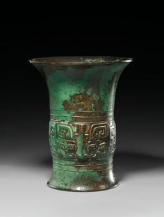 an old green vase with designs on it