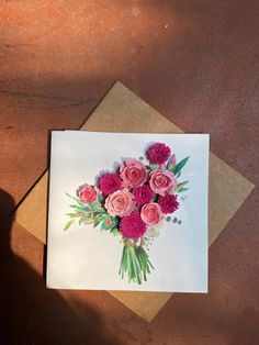 a bouquet of pink flowers on top of a card