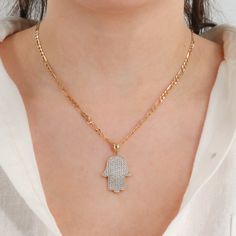 Experience the captivating beauty and spiritual symbolism of our 14k Yellow Gold Cubic Zirconia Hand of Hamsa Pendant. This stunning pendant features a handcrafted design, intricately detailed with a length of 30.6mm (36.5mm with bail) and a width of 20.6mm. Adorned with sparkling cubic zirconia stones, this pendant radiates brilliance and elegance. Crafted with 18k yellow gold and weighing 4.5g, it showcases the perfect balance of luxury and quality. Embrace the protective and positive energy o Spiritual Cubic Zirconia Necklaces With Diamond Accents, Spiritual Necklaces With Diamond Accents, Gold Spiritual Necklace With Diamond Accents, Spiritual Gold Necklaces With Hand-set Details, Spiritual Gold Necklaces With Hand Set Details, Spiritual Hand Set Gold Necklaces, Hand Of Hamsa, Phone Items, Gold Hamsa