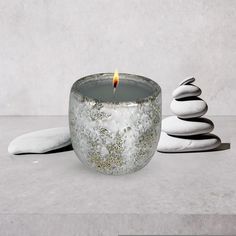 a candle sitting on top of a table next to rocks