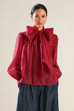 A solid organza top featuring front bow tie, long blouson sleeve with cuff and cami Details: Self : 100% PolyesterLining : 100% Polyester Size & Fit - Model is 5`8" And Wearing Size Small- Measurements Taken From Size Small- Approx. Length: 23.5" Spring Organza Tops For Workwear, Fall Party Top With Tie Sleeves, Fall Party Tops With Tie Sleeves, Tie Sleeve Tops For Fall Parties, Spring Evening Blouse With Bow, Spring Evening Blouse With Bow Detail, Feminine Bow Top For Fall, Chic Tops With Detachable Bow For Spring, Elegant Spring Tops With Satin Bow