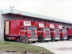 several red trucks parked in front of a building